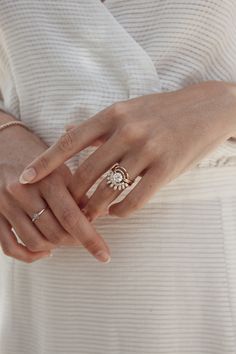 a woman in white dress holding onto her wedding ring