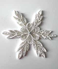 a snowflake made out of white paper on a table