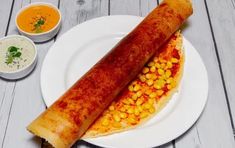 corn on the cob with dipping sauces and a plate full of breadsticks