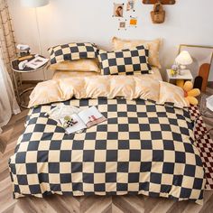 a black and white checkered comforter set on a bed with pillows, pillowcases and lamps