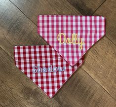 two red and white gingham dog bandanas with the word dolly on them