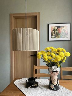 a vase with yellow flowers sitting on top of a table