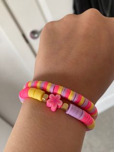 a close up of a person's arm wearing two bracelets with flowers on them