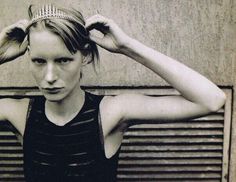 a black and white photo of a woman wearing a tiara with her hands on her head