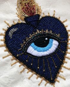 a blue beaded heart with an evil eye