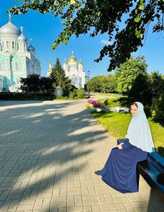 a woman sitting on a bench in front of a building