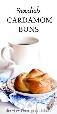 some bread is sitting on a plate next to a cup and saucer with the words swedish cardamom buns