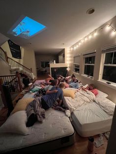 a group of people laying on mattresses in a room