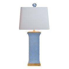 a blue and white table lamp with a light shade on it's base, against a white background