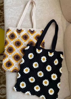 two crocheted bags sitting next to each other on a white couch with yellow and brown flowers