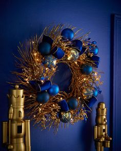 a blue door with a gold wreath and two binoculars on the wall next to it