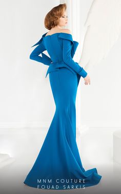 The MNM Couture 2540 is a unique and sophisticated fishtail dress featuring an off-the-shoulder bodice, long sleeves, and a luxurious back panel with geometric folds. Its figure-flattering silhouette is completed by a flirty bow around the waistline, making it a chic and eye-catching choice for any formal event. Luxury Royal Blue Formal Dresses, Luxury Blue Long Sleeve Gown, Luxury Long Sleeve Dresses With Bow, Luxury Long Sleeve Blue Gown, Luxury Blue Off-shoulder Dress, Long Sleeved Gown, Fouad Sarkis, Sleeved Gown, Gorgeous Wedding Dress Princesses