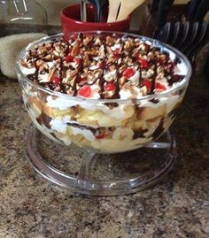 a dessert dish with fruit and nuts in it on a glass platter, ready to be eaten