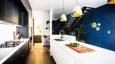 a kitchen with blue walls and white counter tops next to a wooden flooring area