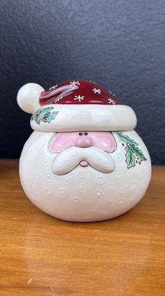 a ceramic santa claus head on top of a wooden table