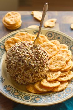 a plate with crackers on it and a cheese ball in the middle surrounded by crackers