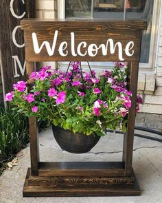 a welcome sign with potted flowers in it