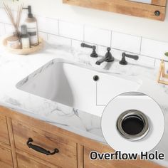 a white sink sitting under a mirror next to a faucet in a bathroom