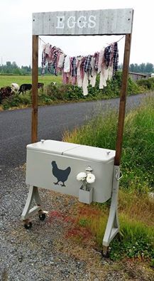 an old cooler sitting on the side of a road next to a sign that says bags