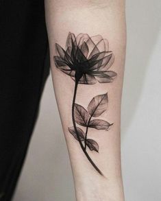 a black and white photo of a flower on the left arm with leaves around it