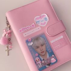 a pink passport case with a keychain attached to it and a photo on the front