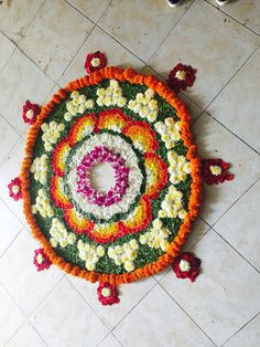 a colorful rug on the floor is made with flowers and leaves, which are arranged in a circle