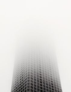 a very tall building in the middle of a foggy day