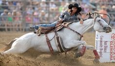 a woman riding on the back of a white horse