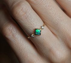 A stunning one of a kind genuine square Australian black opal and round diamond ring with beautiful interchangeable green and blue tones. Perfect as a modern and unique engagement, wedding or anniversary princess ring. A three stone ring, available in 14k yellow gold as seen online and ready for shipping in just a few days after purchase. Please select the ring size from the drop-down menu. If you have any questions, please send us a message. If you would prefer other gemstones instead of diamon Opal Diamond Engagement Ring, Gold Engagement Band, Three Stone Wedding Ring, Rose Gold Diamond Band, Spinel Engagement Rings, Engagement Ring Princess, Stone Wedding Ring, Black Spinel Ring, Blue Opal Ring