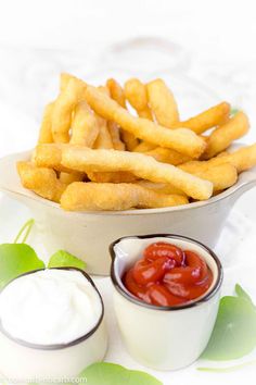 french fries with ketchup and mayonnaise in a bowl on a table