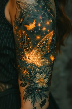 a woman's arm covered in tattoos with flowers and butterflies on the back of it