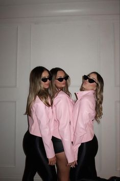 three women wearing pink jackets and black pants