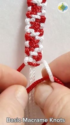 someone is making a piece of red and white string