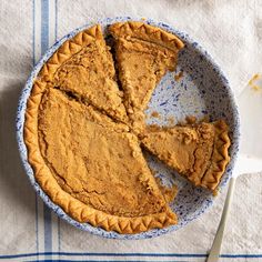 a pie sitting on top of a blue plate next to a white and blue towel