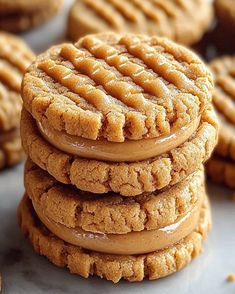 several cookies stacked on top of each other with peanut butter frosting in the middle