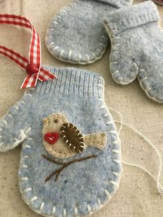 two blue mittens and one with a bird on it