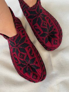 someone is wearing slippers with black and red designs on them