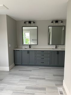 a large bathroom with two sinks and mirrors on the wall next to eachother