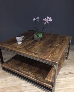 a wooden table with metal legs and a flower in a vase on the bottom shelf