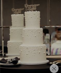 three tiered wedding cake with white frosting