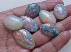 several different colored rocks in someone's hand