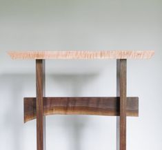 a wooden table sitting on top of a white wall