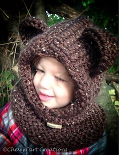 a young child wearing a bear hat and scarf