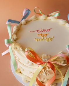 a close up of a cake on a plate with ribbons around it and an inscription