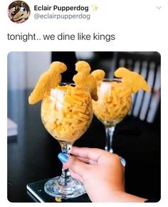 two glasses filled with macaroni and cheese sitting on top of a table