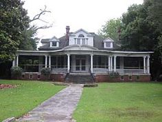 a large white house sitting on top of a lush green field