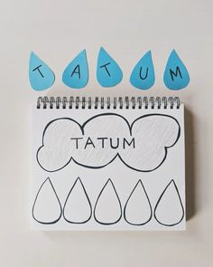 a notebook with the word autumn written on it and raindrops drawn in front of it