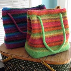 two multicolored bags sitting on top of a suitcase