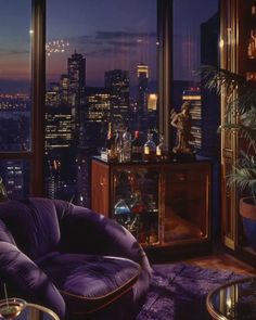 a living room filled with furniture and a view of the city lights at night in the distance