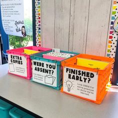 three plastic bins with labeled labels on them sitting on a table in front of a window